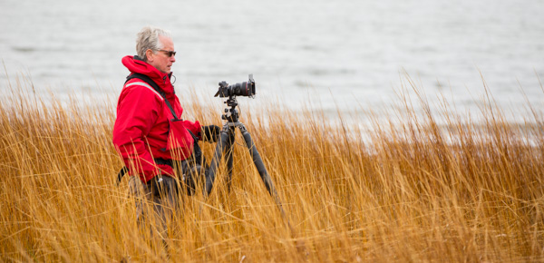 phil nelson standing in beach grass with camera and tripod